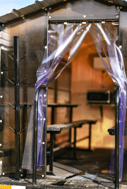 View through the strip curtain entry of an Anvil Rentals trailer into the conditioned interior seating area